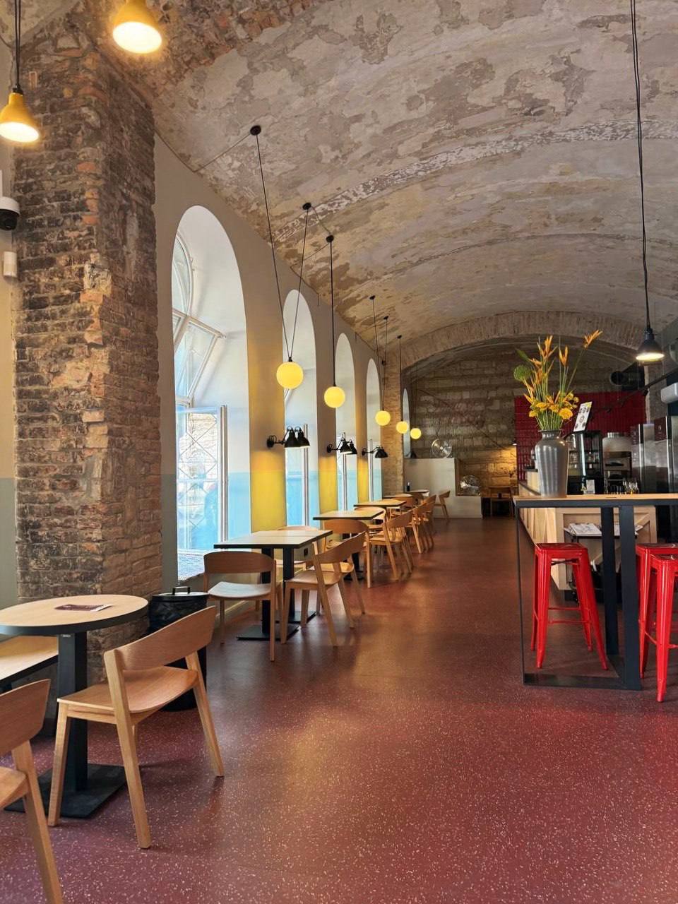 Зал Coffee Capital — арочные своды, деревянные столики и жёлтые подвесные лампы